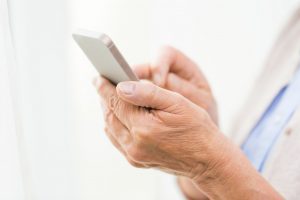 47663903 - technology, communication age and people concept - close up of senior woman hands with smartphone texting message at home